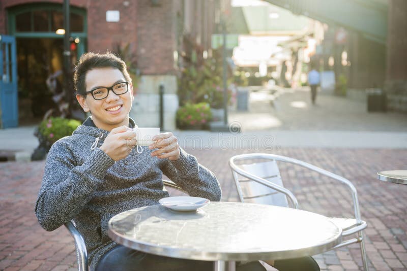Homem asiático novo no café exterior imagens de stock