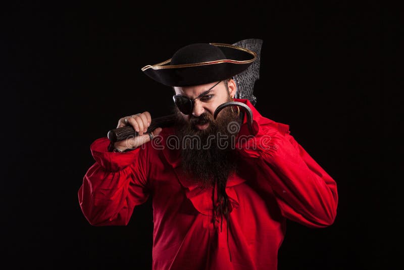 Retrato de um homem barbudo bonito em uma fantasia de pirata, olhando sério  para a câmera para o halloween. homem vestido de pirata do caribe.