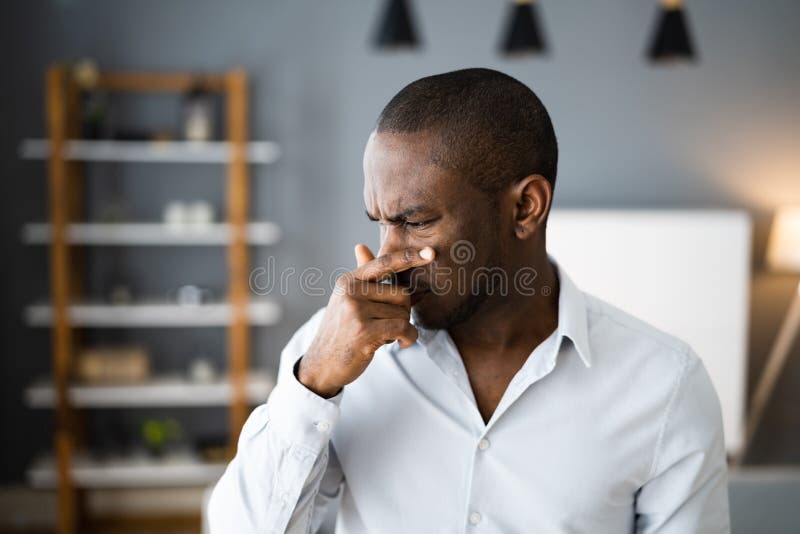 Homem cobrindo seu nariz de mau cheiro