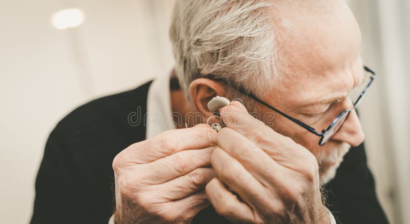 Homem colocando aparelhos auditivos