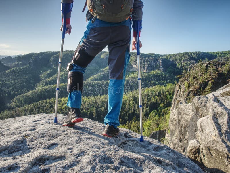 Homem com muletas e vontade forte Escalada deficiente do turista fotografia de stock Homem com muletas e vontade forte Escalada deficiente do turista fotografia de stock