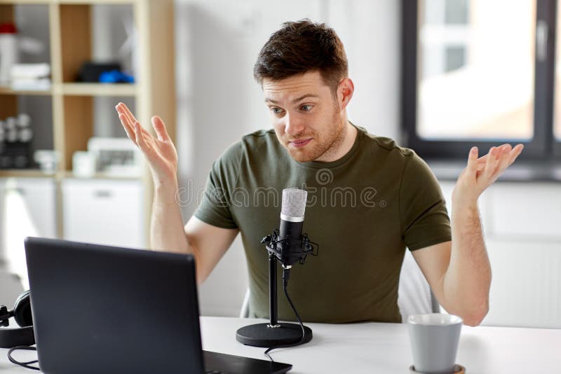Homem com o escrit?rio do port?til e do microfone em casa fotografia de stock royalty free Homem com o escrit?rio do port?til e do microfone em casa fotografia de stock royalty free