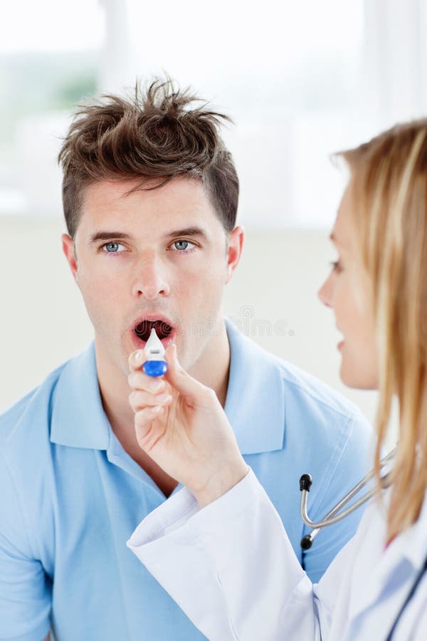 Homem considerável com seu doutor que toma a temperatura imagem de stock Homem considerável com seu doutor que toma a temperatura imagem de stock