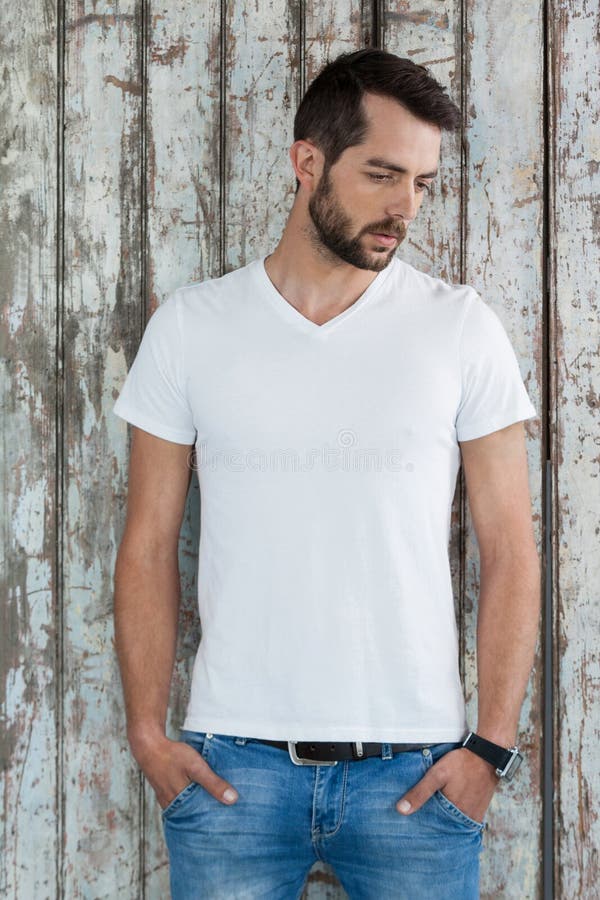 Homem considerável no t-shirt e na calças de ganga brancos fotografia de stock royalty free Homem considerável no t-shirt e na calças de ganga brancos fotografia de stock royalty free