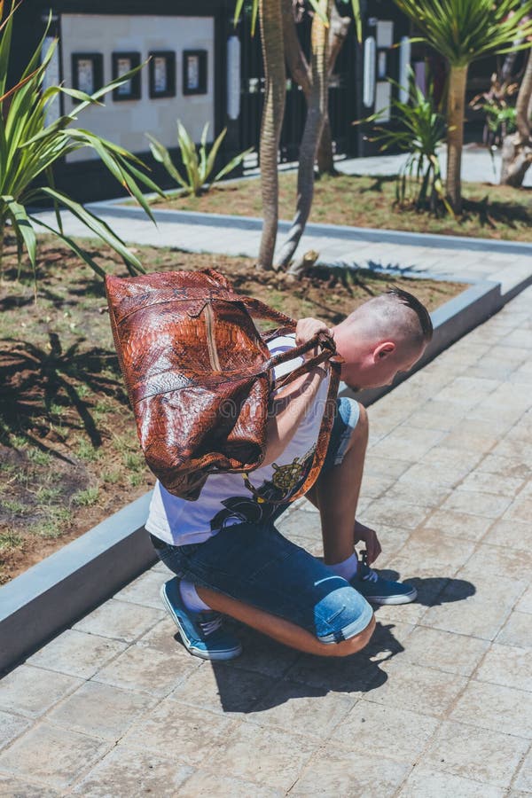Homem considerável novo com o saco luxuoso do curso do pitão do snakeskin Console de Bali, Indonésia fotografia de stock royalty free Homem considerável novo com o saco luxuoso do curso do pitão do snakeskin Console de Bali, Indonésia fotografia de stock royalty free