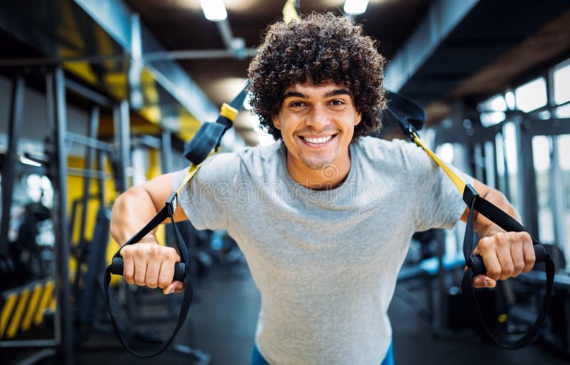 Homem considerável novo que faz exercícios no gym imagem de stock Homem considerável novo que faz exercícios no gym imagem de stock