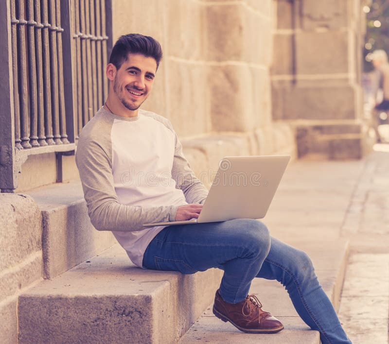 Homem considerável novo que trabalha e que estuda no portátil em um europeu fotos de stock royalty free Homem considerável novo que trabalha e que estuda no portátil em um europeu fotos de stock royalty free