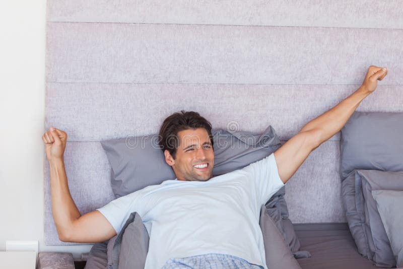 Homem atraente a acordar e a espreguiçar imagem de stock royalty free