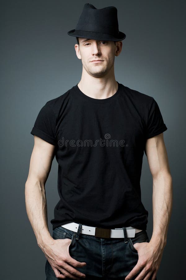 Homem considerável que levanta no t-shirt e no bla pretos fotografia de stock royalty free Homem considerável que levanta no t-shirt e no bla pretos fotografia de stock royalty free