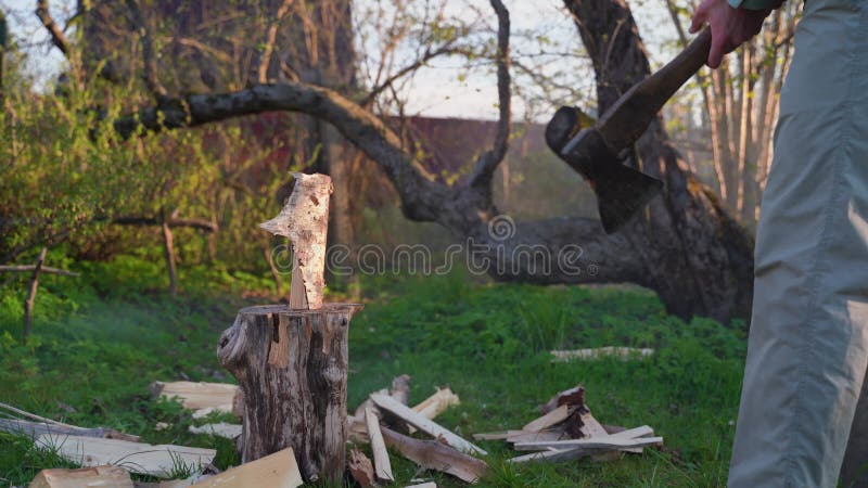 Homem corta madeira numa almofada de madeira. registro de cortes de machados enferrujados
