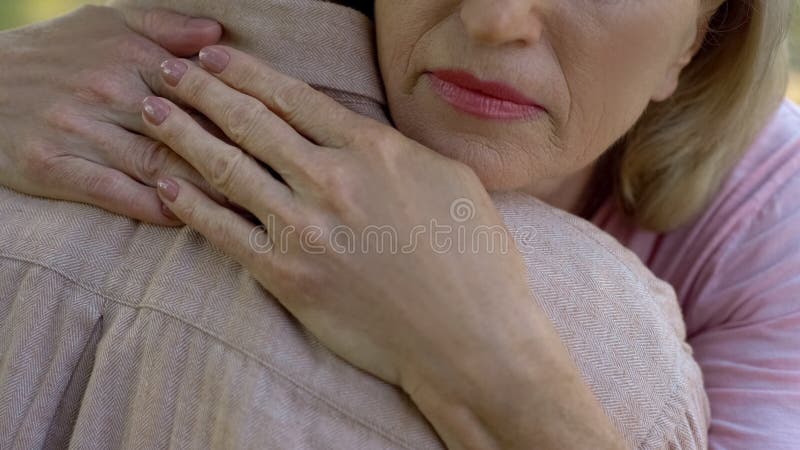 Homem de abraço da mulher superior após más notícias sobre a doença ou a perda, apoio da família fotografia de stock Homem de abraço da mulher superior após más notícias sobre a doença ou a perda, apoio da família fotografia de stock