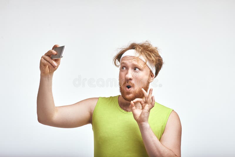 Homem de cabelo, farpado, gordo vermelho que sorri e que toma um selfie fotografia de stock Homem de cabelo, farpado, gordo vermelho que sorri e que toma um selfie fotografia de stock