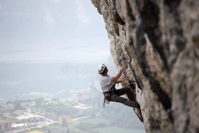 Homem de escalada em uma parede de pedra imagem de stock Homem de escalada em uma parede de pedra imagem de stock