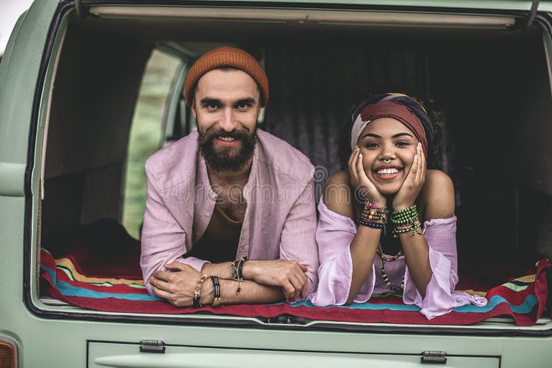 Homem de Hippie e mulher deitados no porta-malas de retro van foto de stock Homem de Hippie e mulher deitados no porta-malas de retro van foto de stock