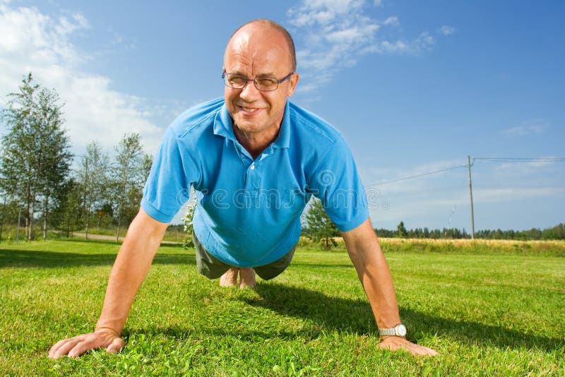 Homem de meia idade que faz push-ups fotos de stock Homem de meia idade que faz push-ups fotos de stock