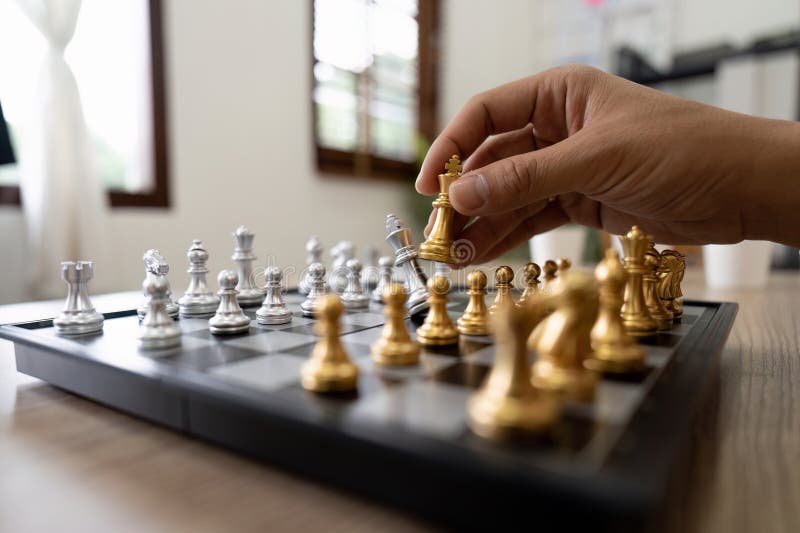 Mão Do Homem De Negócios Jogando Xadrez. Mão Do Homem De Negócios Segurando  A Peça Da Rainha Do Xadrez Sobre O Tabuleiro De Xadrez. Estratégia De  Negócios Para A Vitória. Foto Royalty