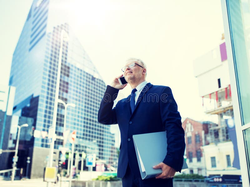 Homem de neg?cios superior que chama o smartphone na cidade foto de stock Homem de neg?cios superior que chama o smartphone na cidade foto de stock
