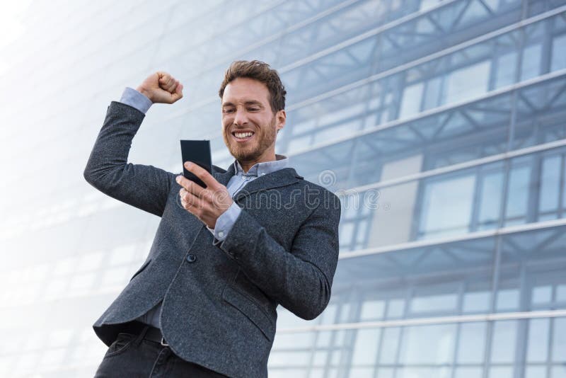 Homem de negócio do vencedor do sucesso que ganha no app do telefone celular Homem de negócios Cheering que olha o desafio ou o t fotografia de stock royalty free Homem de negócio do vencedor do sucesso que ganha no app do telefone celular Homem de negócios Cheering que olha o desafio ou o t fotografia de stock royalty free