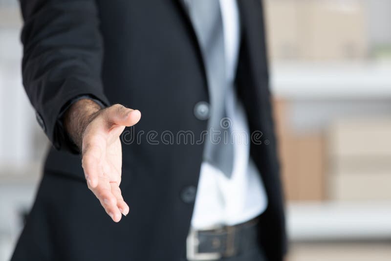 Homem de negócio na mão aberta do terno preto pronta para agitar as mãos, paridade foto de stock Homem de negócio na mão aberta do terno preto pronta para agitar as mãos, paridade foto de stock