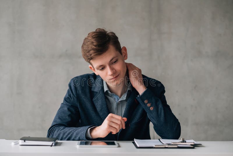 Homem de negócio novo confuso da rotina do escritório foto de stock Homem de negócio novo confuso da rotina do escritório foto de stock