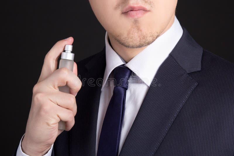 Homem de negócio novo considerável que usa o perfume foto de stock Homem de negócio novo considerável que usa o perfume foto de stock