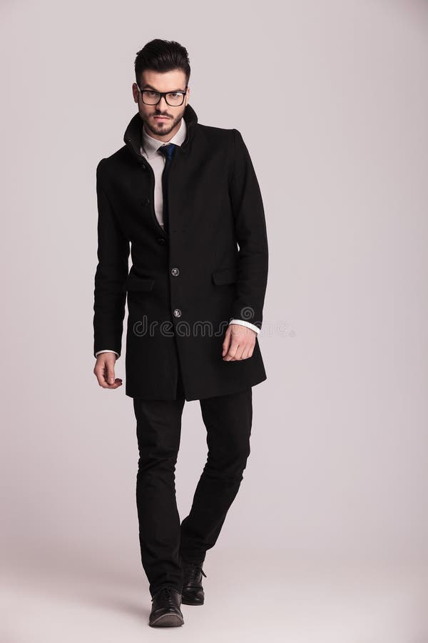 Homem de negócio novo considerável que veste um revestimento preto longo foto de stock royalty free Homem de negócio novo considerável que veste um revestimento preto longo foto de stock royalty free