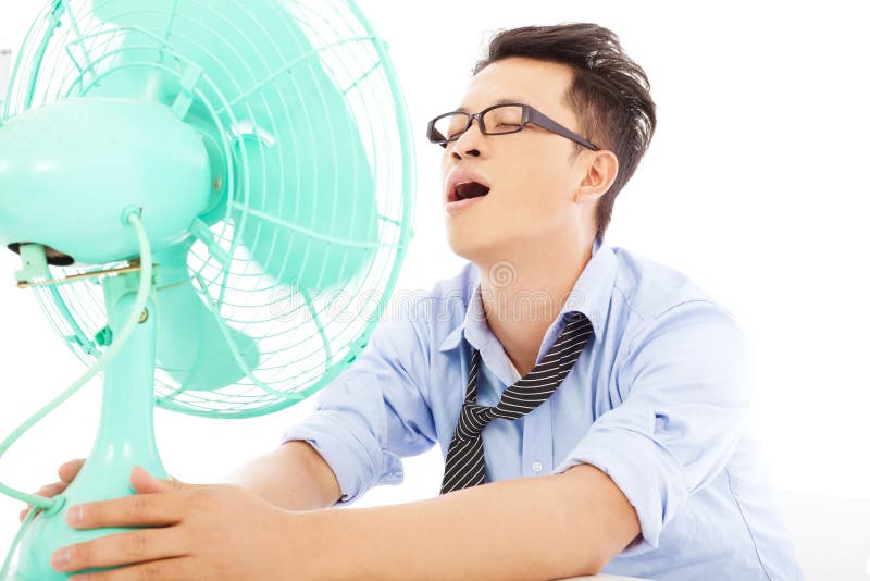 Homem de negócio que sofre um calor quente do verão com fãs