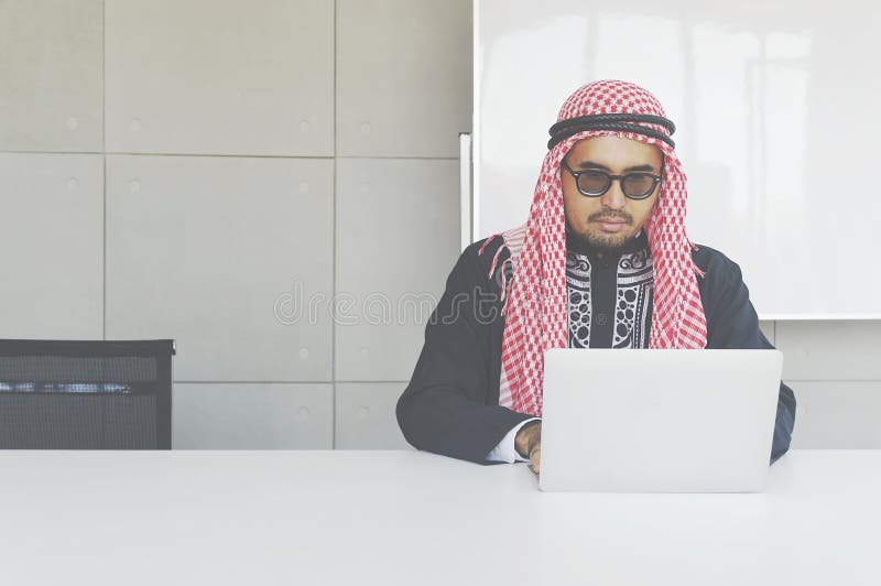 Homem de negócio árabe que trabalha no portátil foto de stock royalty free Homem de negócio árabe que trabalha no portátil foto de stock royalty free