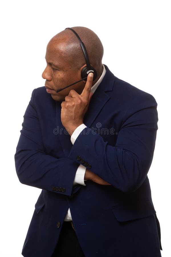 Homem de negócios afro-americano Listens Through Headset fotos de stock Homem de negócios afro-americano Listens Through Headset fotos de stock