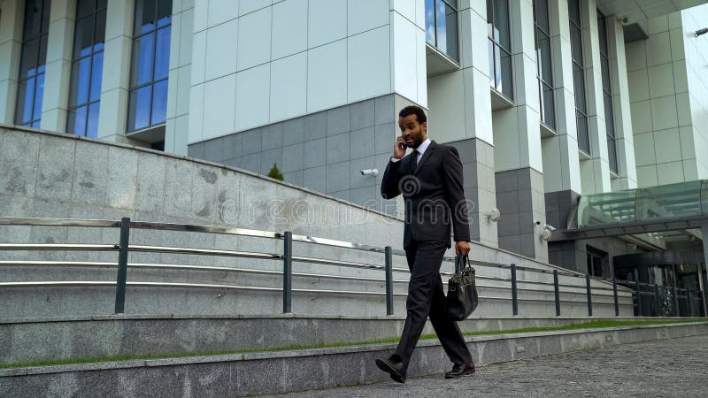 Homem de negócios afro-americano que fala no telefone, forçado e sobrecarregado, fim do prazo fotos de stock Homem de negócios afro-americano que fala no telefone, forçado e sobrecarregado, fim do prazo fotos de stock
