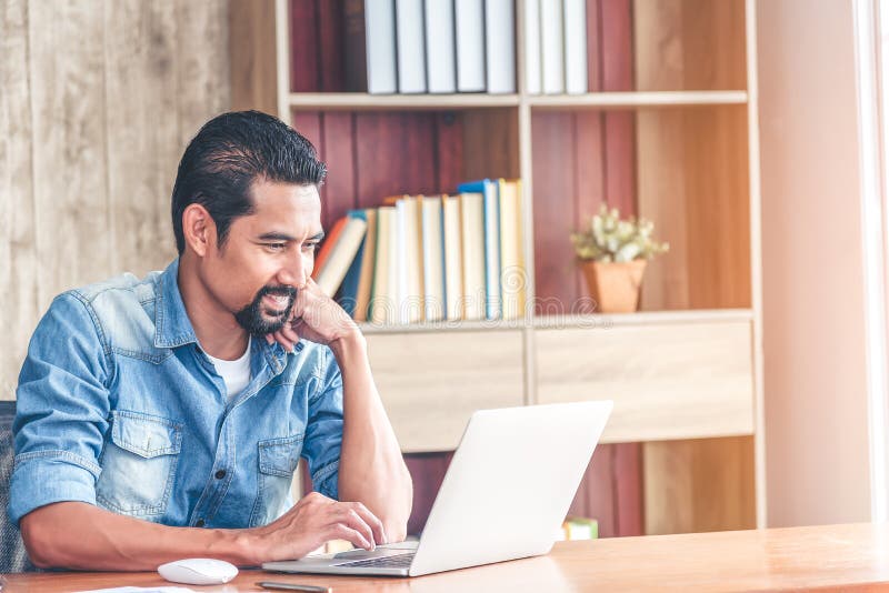 Homem de negócios asiático bonito sorrindo depois de receber uma notícia de mercadoria ou receber um novo projeto de trabalho Jov fotos de stock royalty free Homem de negócios asiático bonito sorrindo depois de receber uma notícia de mercadoria ou receber um novo projeto de trabalho Jov fotos de stock royalty free