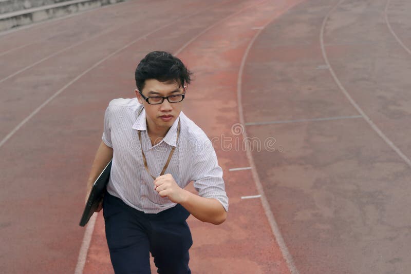Homem de negócios asiático novo seguro com a corrida pronta do portátil a enviar no autódromo Conceito da visão do negócio fotos de stock Homem de negócios asiático novo seguro com a corrida pronta do portátil a enviar no autódromo Conceito da visão do negócio fotos de stock