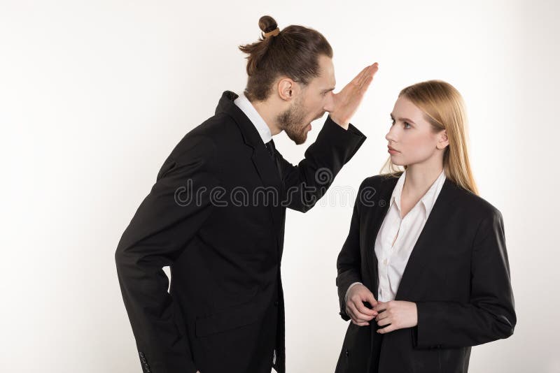 Homem de negócios atrativo com barba e penteado na moda no terno preto que gritam em seu subordinado que não pode lidar imagens de stock royalty free Homem de negócios atrativo com barba e penteado na moda no terno preto que gritam em seu subordinado que não pode lidar imagens de stock royalty free