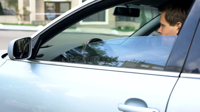 Homem de negócios bem sucedido novo que senta-se no banco do condutor do carro, pronto para ir para o trabalho fotografia de stock Homem de negócios bem sucedido novo que senta-se no banco do condutor do carro, pronto para ir para o trabalho fotografia de stock