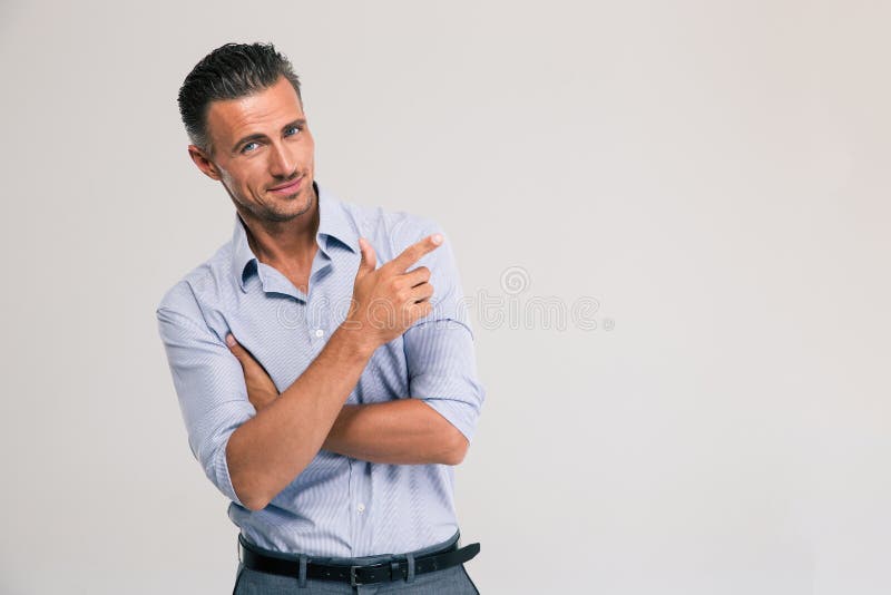 Homem de negócios de sorriso que aponta o dedo afastado fotografia de stock Homem de negócios de sorriso que aponta o dedo afastado fotografia de stock