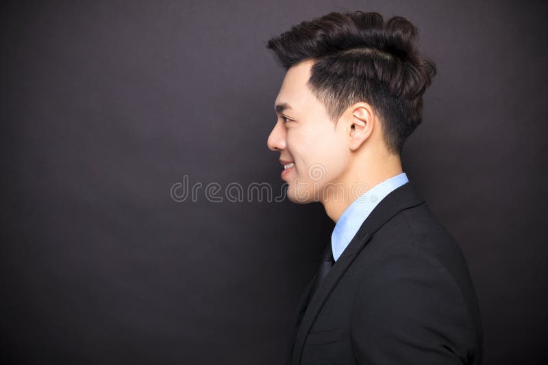Homem de negócios de sorriso que está antes do fundo preto fotografia de stock Homem de negócios de sorriso que está antes do fundo preto fotografia de stock