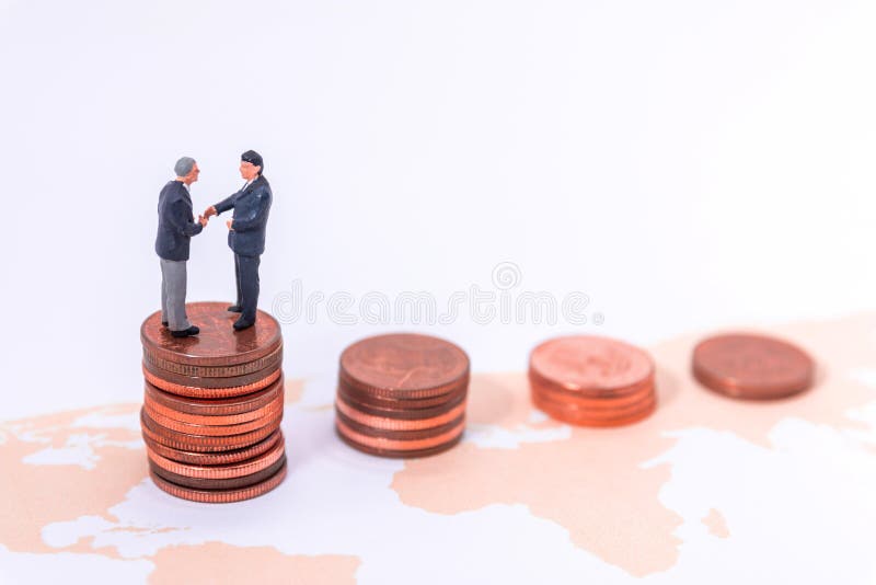 Homem de negócios diminuto Handshake no mapa do mundo no blackground branco imagens de stock royalty free Homem de negócios diminuto Handshake no mapa do mundo no blackground branco imagens de stock royalty free