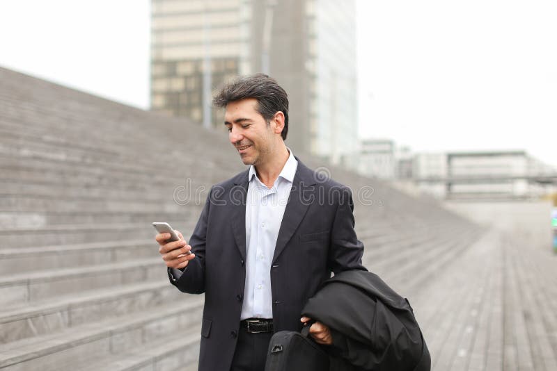 Homem de negócios europeu que anda e que fala pelo telefone fotos de stock royalty free Homem de negócios europeu que anda e que fala pelo telefone fotos de stock royalty free