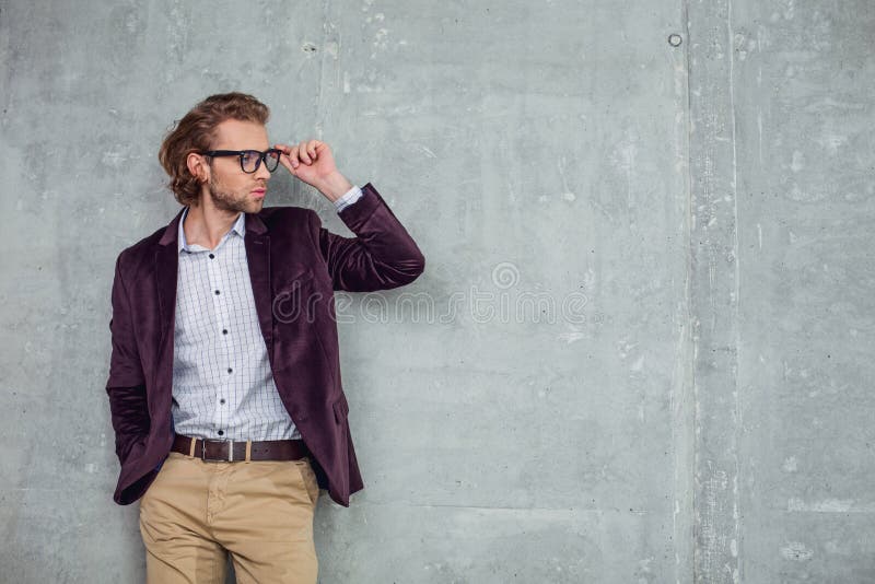 Homem de negócios farpado seguro que inclina-se contra a parede imagens de stock Homem de negócios farpado seguro que inclina-se contra a parede imagens de stock