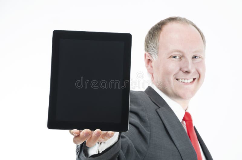 Homem de negócios feliz que apresenta (sth sobre) a tabuleta digital foto de stock royalty free Homem de negócios feliz que apresenta (sth sobre) a tabuleta digital foto de stock royalty free