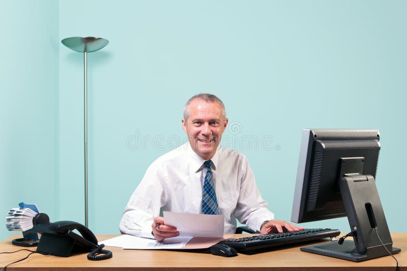 Homem de negócios maduro sentado em sua mesa de escritório