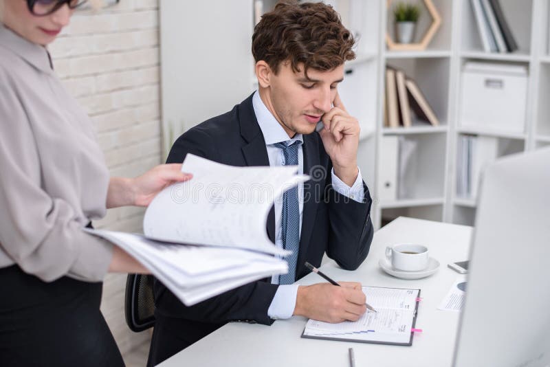 Homem de negócios novo Busy Working no escritório foto de stock Homem de negócios novo Busy Working no escritório foto de stock