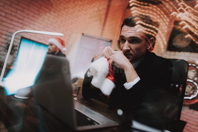 Homem de negócios novo cansado no escritório na véspera de ano novo imagem de stock royalty free Homem de negócios novo cansado no escritório na véspera de ano novo imagem de stock royalty free