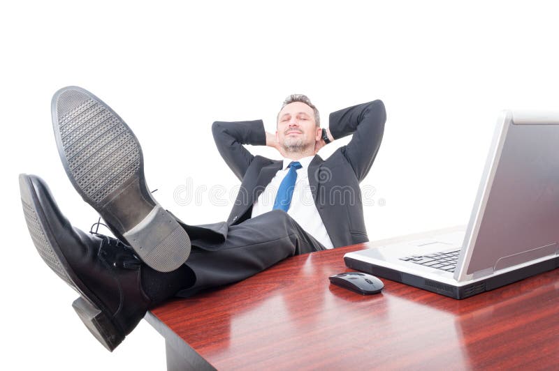 Homem de negócios novo que relaxa em seu escritório imagem de stock Homem de negócios novo que relaxa em seu escritório imagem de stock