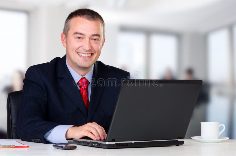 Homem de negócios novo que trabalha em seu escritório foto de stock royalty free Homem de negócios novo que trabalha em seu escritório foto de stock royalty free