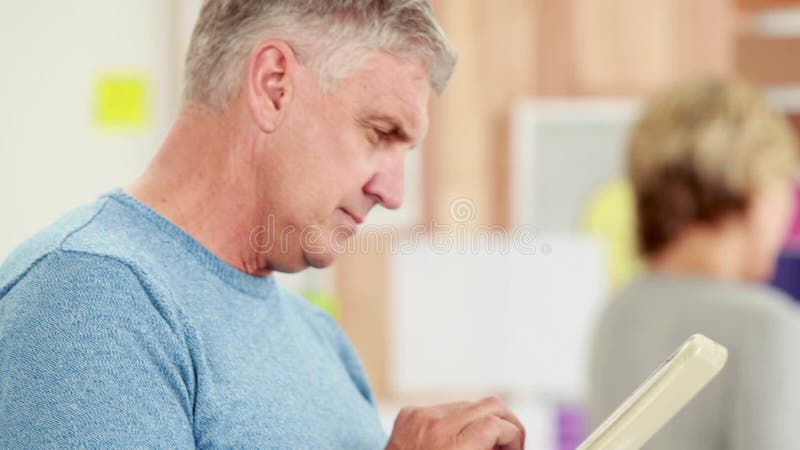 Homem de negócios ocasional feliz que usa a tabuleta