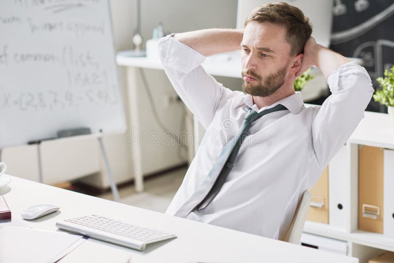 Homem de negócios pensativo considerável na mesa imagem de stock royalty free Homem de negócios pensativo considerável na mesa imagem de stock royalty free