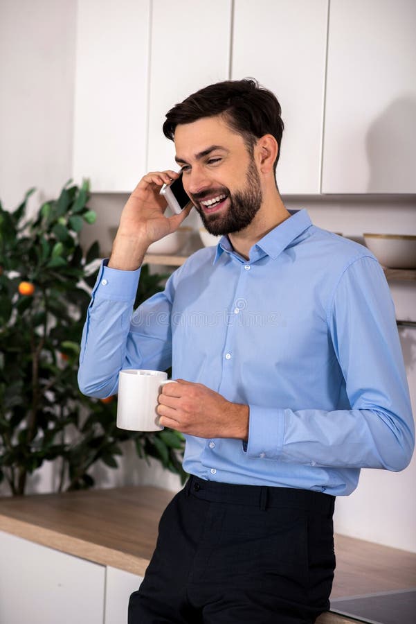 Homem de negócios positivo que fala no telefone esperto imagens de stock Homem de negócios positivo que fala no telefone esperto imagens de stock