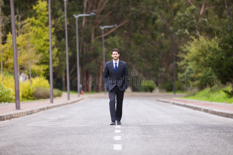Homem de negócios que anda na linha da estrada imagens de stock Homem de negócios que anda na linha da estrada imagens de stock