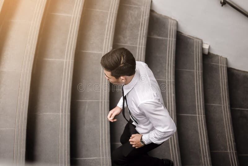 Homem de negócios que corre acima a escadaria que vai trabalhar fotografia de stock Homem de negócios que corre acima a escadaria que vai trabalhar fotografia de stock